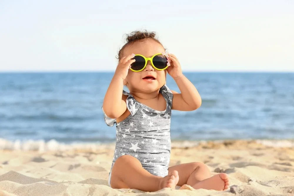 baby on the beach wearing sunglasses