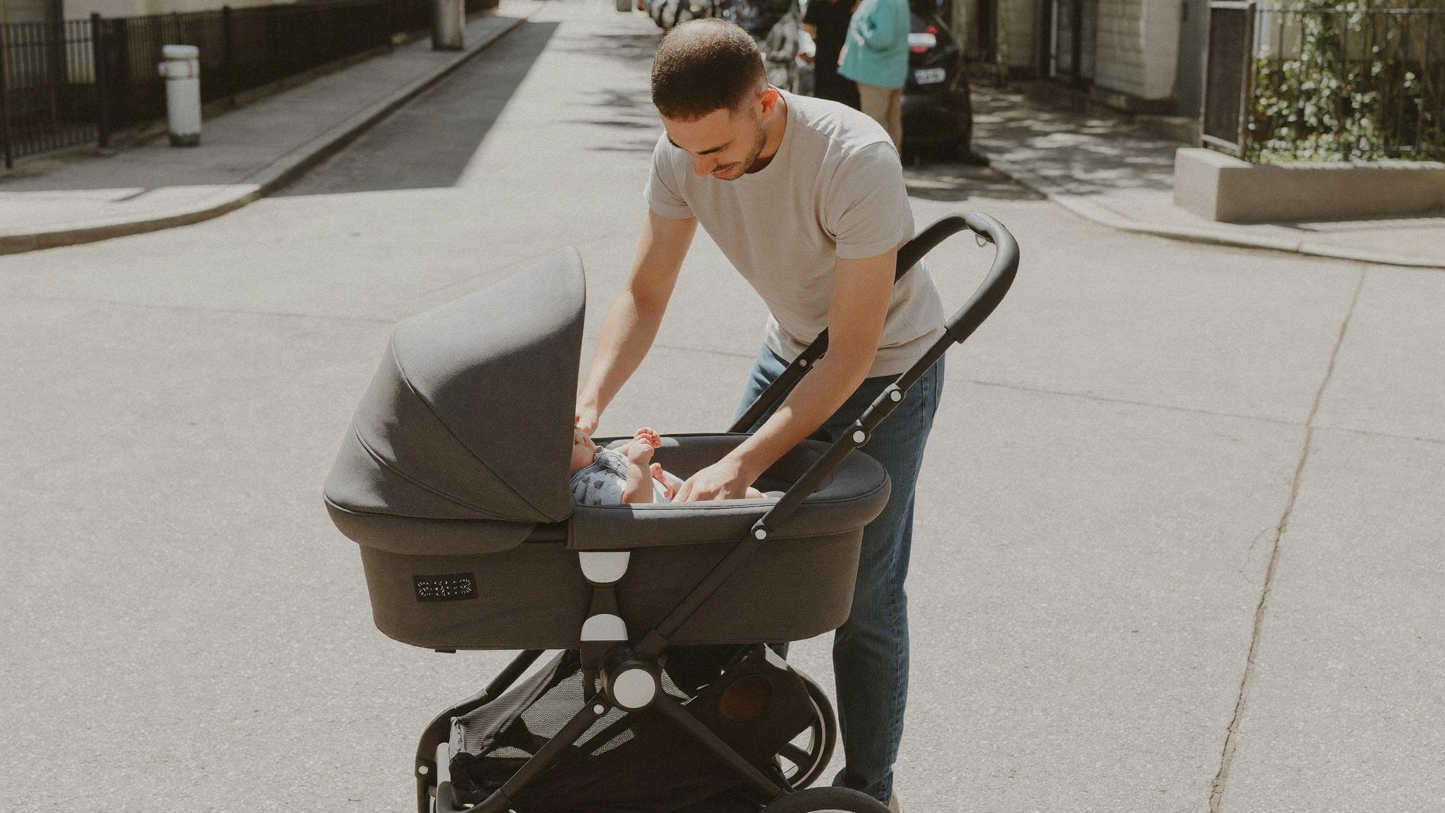 Father settling his baby into a 2-in-1 pram carrycot - Bambinos & Beyond 2-in-1 Travel Systems