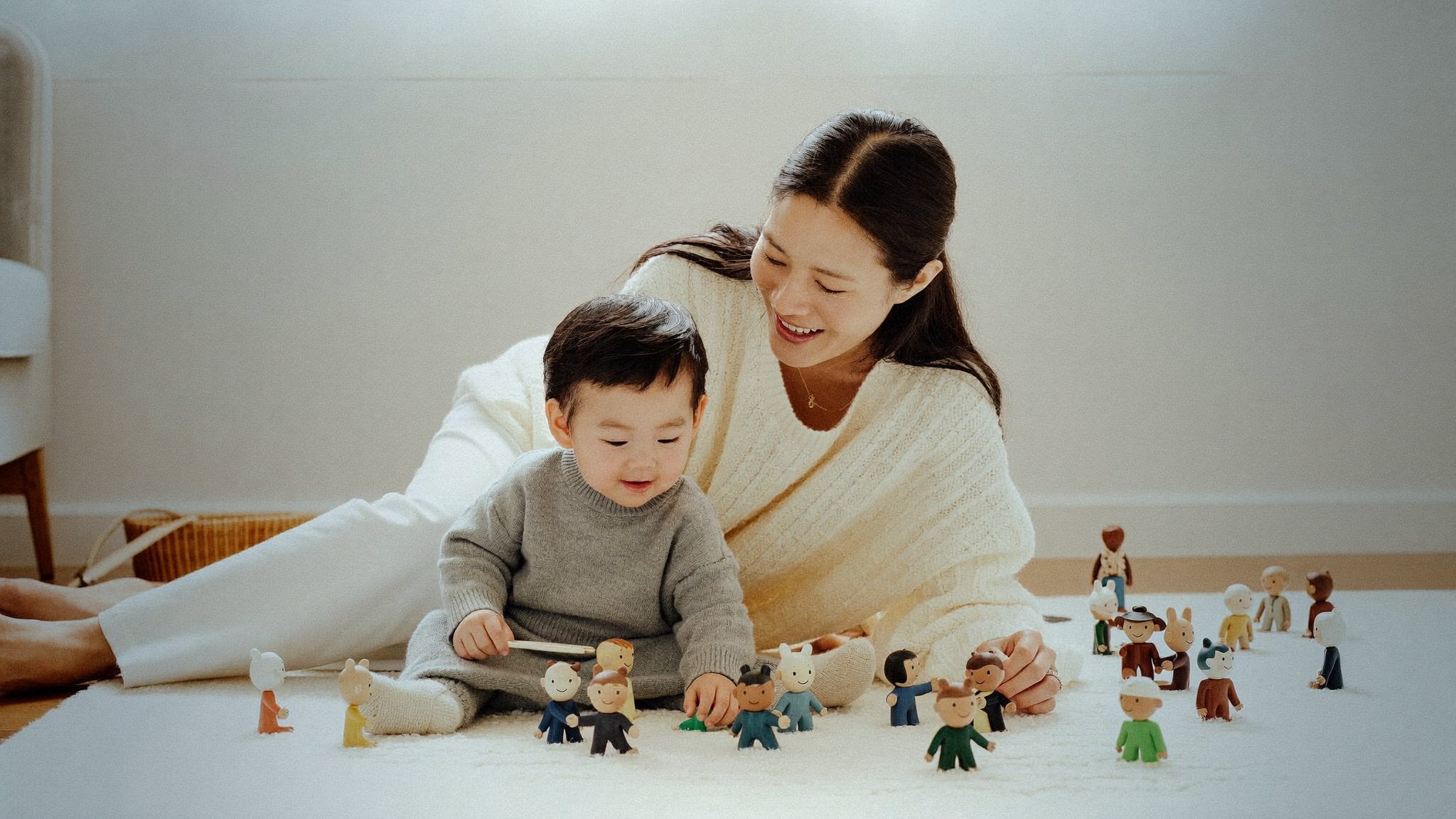 Toddler playing with wooden audio character figures beside mum - Bambinos & Beyond Tonies Figures